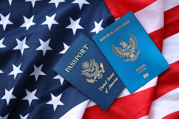 Passport of Indonesia with US Passport on United States of America folded flag close up