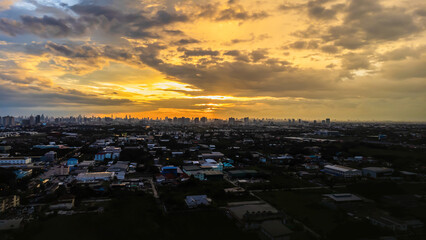 Aerial view of coastal city at dusk The sky is purple-orange as the sun sets over the city, buildings are dense. It is a mix of skyscrapers and low-rise buildings.