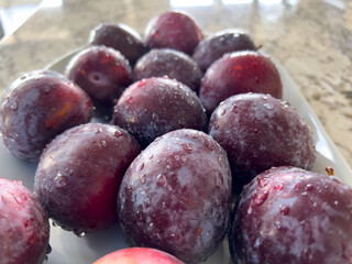 Fresh Plums on a Plate in a Bright Modern Kitchen Setting - 786771784