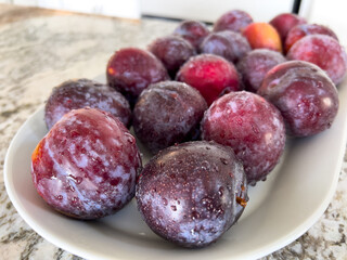 Fresh Plums on a Plate in a Bright Modern Kitchen Setting - 786771928
