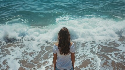 Fototapeta premium Girl standing against the backdrop of the ocean