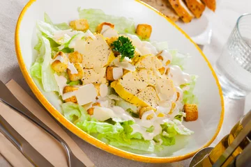 Gordijnen Caesar salad on plate at restaurant © JackF