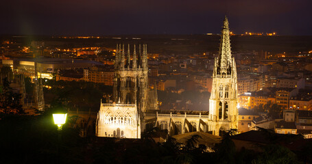 View of landmark of famous cathedral in Burgos city illuminated at dusk in Castilla Leon, Spain - obrazy, fototapety, plakaty