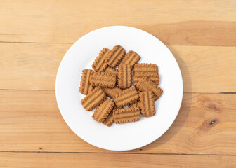 Sweet Brown biscuit bars in white plate on a wooden background