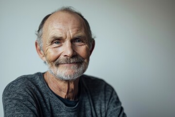 Portrait of a senior man with grey hair looking at camera.