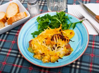 Poster Portion of fried potatoes with pork steak with onion and cheese, popular dish of eastern Europe © JackF