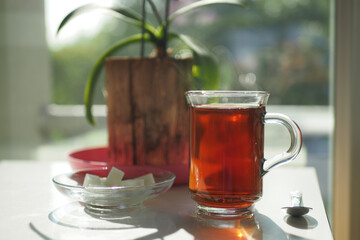 early morning green tea and sugar on table near window 