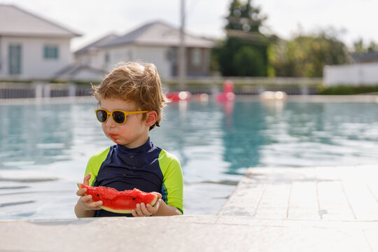 Happy vacation kid boy eat watermelon have fun enjoy at swimming pool. children cheerful activity relaxing in summer holiday.