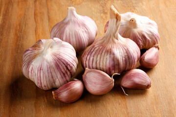 Close Up Raw, Fresh Garlic Cloves and Bulbs on Rustic Wooden Table