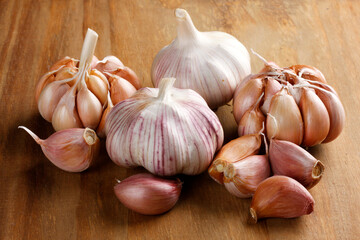 Close Up Raw, Fresh Garlic Cloves and Bulbs on Rustic Wooden Table