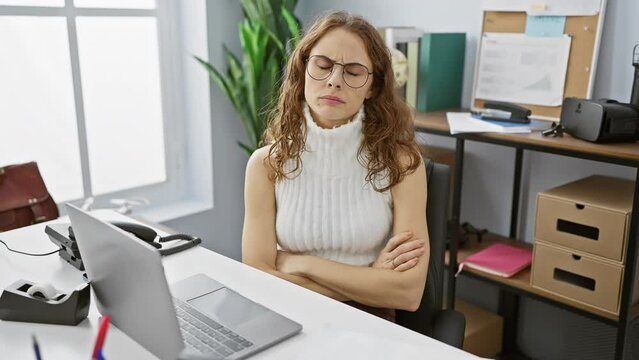Skeptic young woman with nervous, disapproving expression working in office. a beautiful person with crossed arms showing a negative face.