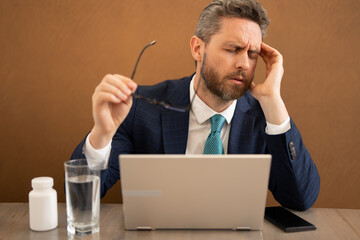Headache and eye strain on laptop. Business man with stress and fatigue eyestrain. Businessman...