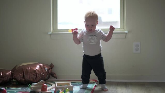 one year old kid, boy takes the first step into the room