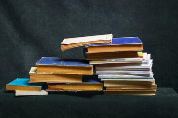 A stack of old books and notebooks on the table