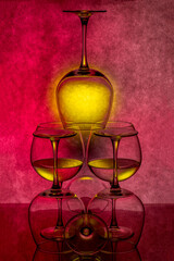 Still life with glassware with liquid on colored background