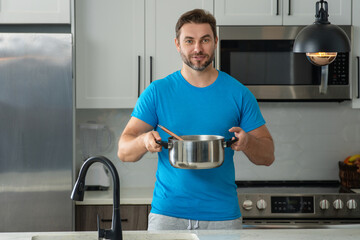 Cooking food at home. Man in kitchen preparing a meal. Male cook preparing food in kitchen at home. Chef cooking meal. Man cooking food, kitchen pot food plate. Man preparing soup on kitchen interior.