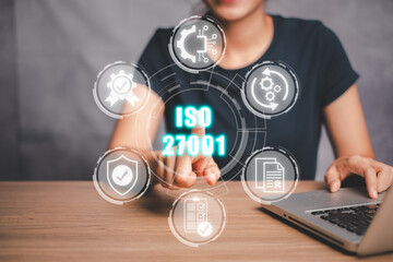 Iso 27001 concept, Businesswoman using laptop computer on desk and hand touching iso 27001 icon on...
