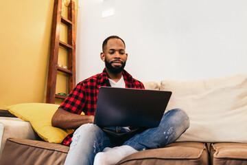 African american man teleworking with laptop from home