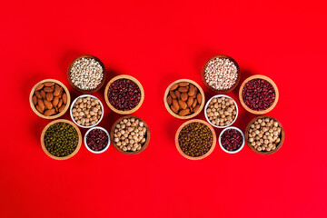 Mung beans, Red kidney beans, Chickpeas source and peeled barley in white cup on spoon wooden on red background