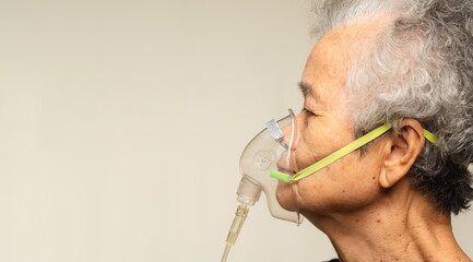 An elderly woman using an oxygen mask.