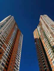 Modern new residential concrete skyscrapers against the sky. Front view of a part of a multi-storey new building.