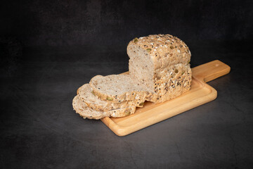 Stack grain loaf bread on a tray with black background