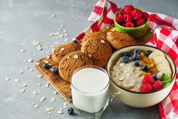 tasty nutritious oatmeal with fruits and berries on a light stone background