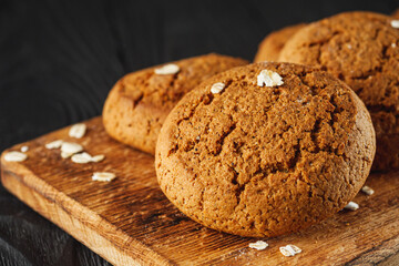 oatmeal cookies with a glass of milk on a black wooden rustic background