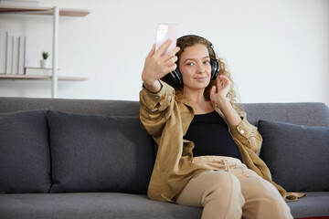 young woman with headphones and listen to music from smartphone