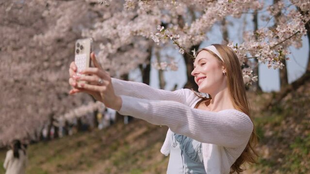 Cheerful Female Taking Selfie With Her Mobile Phone At Yangjae Citizen's Forest Park In Seocho District, Seoul City, South Korea. Zoom Out Shot