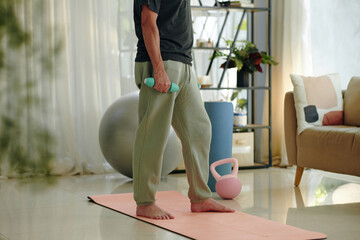 Cropped image of mature man exercise with dumbbells at home