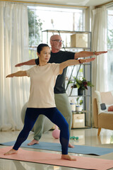 Active diverse couple practicing yoga at home