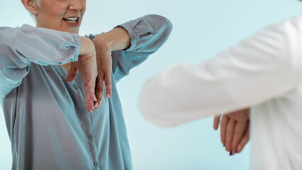 Doctor conducts a thorough examination for Carpal Tunnel Syndrome with a senior woman, a common...