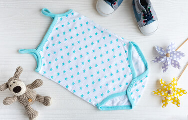 Blue romper  with knittes toy dog, toy windmills  and baby shoes.