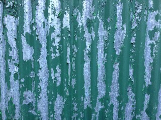 Peeling green paint corrugated iron