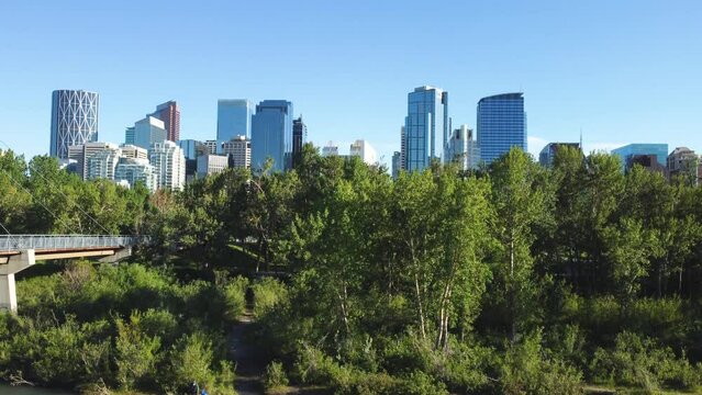 Downtown Calgary, Alberta, Canada skyline. Wide aerial drone view, from the Bow River on a sunny blue skies day. Prince Island Park.
