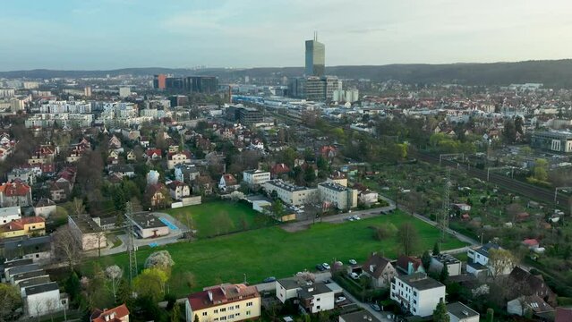 Expansive aerial view over a mixed urban landscape with residential houses, towering office buildings, and green spaces - OBC, Oliwa, Gdańsk