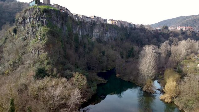 Master Shot: Castellfollit de la Roca - The Cliffside Town in Girona&rsquo;s Pyrenees, Near Garrotxa Volcanic Zone. Catalonia Spain. Tourist Attraction, Natural Wonder of the World. El Fluvia River.