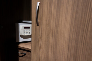 Close up code lock on the safe door.Safe for customer in hotel room.Press key on safety lock...