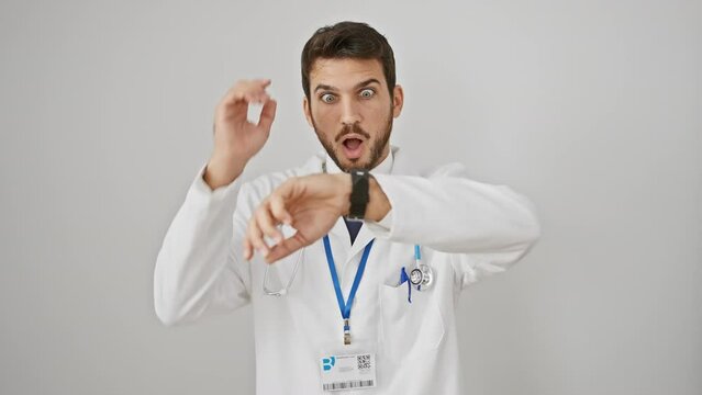 Worried young hispanic man, stethoscope-wearing doctor, checking watch in rush, afraid of being late, isolated on white background
