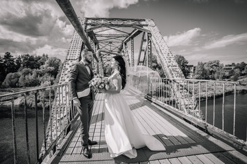 Valmiera, Latvia- July 28, 2024 - In a black and white photo, a bride and groom stand on an old...