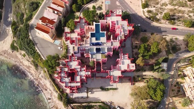 'The Red Wall' building, Calpe Spain. La Muralla Roja, Red architectural building, with unique design. Aerial drone view. Mediterranean Coastal mountain View. Birds Eye view looking down.