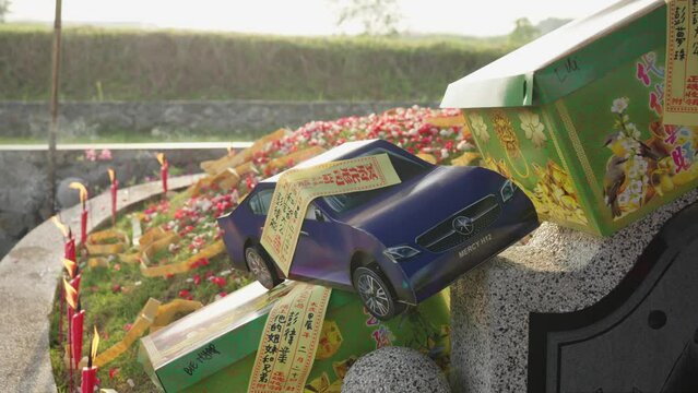 Chinese Ancestor Honoring Rituals with Paper Cars for Qingming Festival
