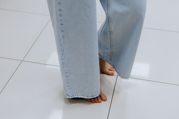 Close up of woman legs tries on clothes while looking at herself in the mirror in the locker room, posing, shopping for casual clothes, in fashionable women's clothing store, in boutique. Shopping.