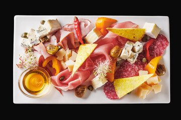 a tray of assorted meat and cheese on a light stone background