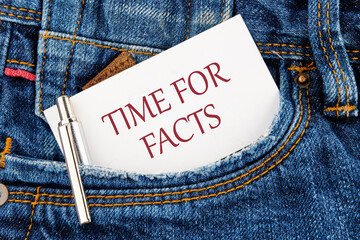 Time for facts message written on a business card peeking out of a jeans pocket