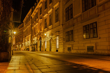 Kurrentgasse in Wien bei Nacht, Lichter spiegeln sich auf Pflastersteinen, 