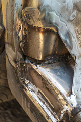the silver car has a hole in the doorway due to old age and poor care. repair. close-up