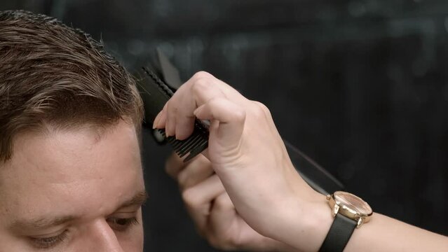 Close-up of a stylist using clippers on a client's hair