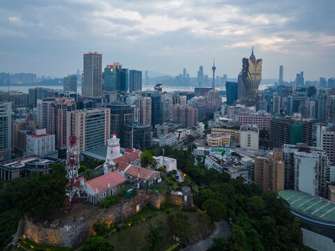 Macau, China - October 16 2023: Aerial view of the Guia hill and fortress that overlook Macau skyline with the iconic Grand Lisboa casino in China at dusk